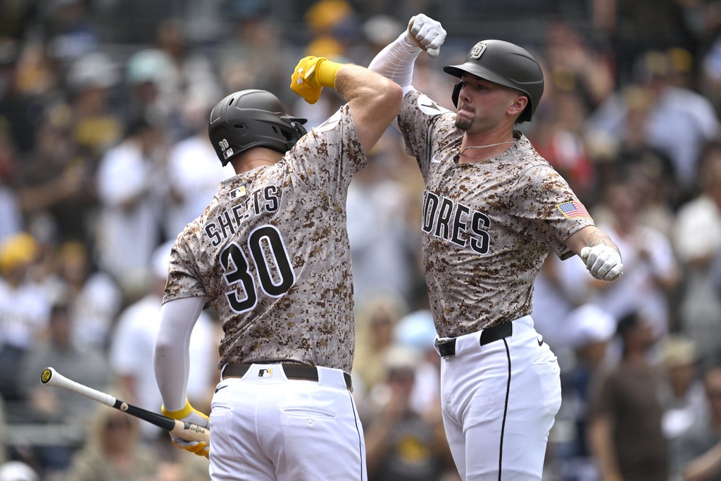 San Diego Padres' Jackson Merrill, right, celebrates with Gavin Sheets (30) after hitting a three-run home run against the Colorado Rockies during the second inning of a baseball game Sunday, Sept. 14, 2025, in San Diego. (AP Photo/Orlando Ramirez)