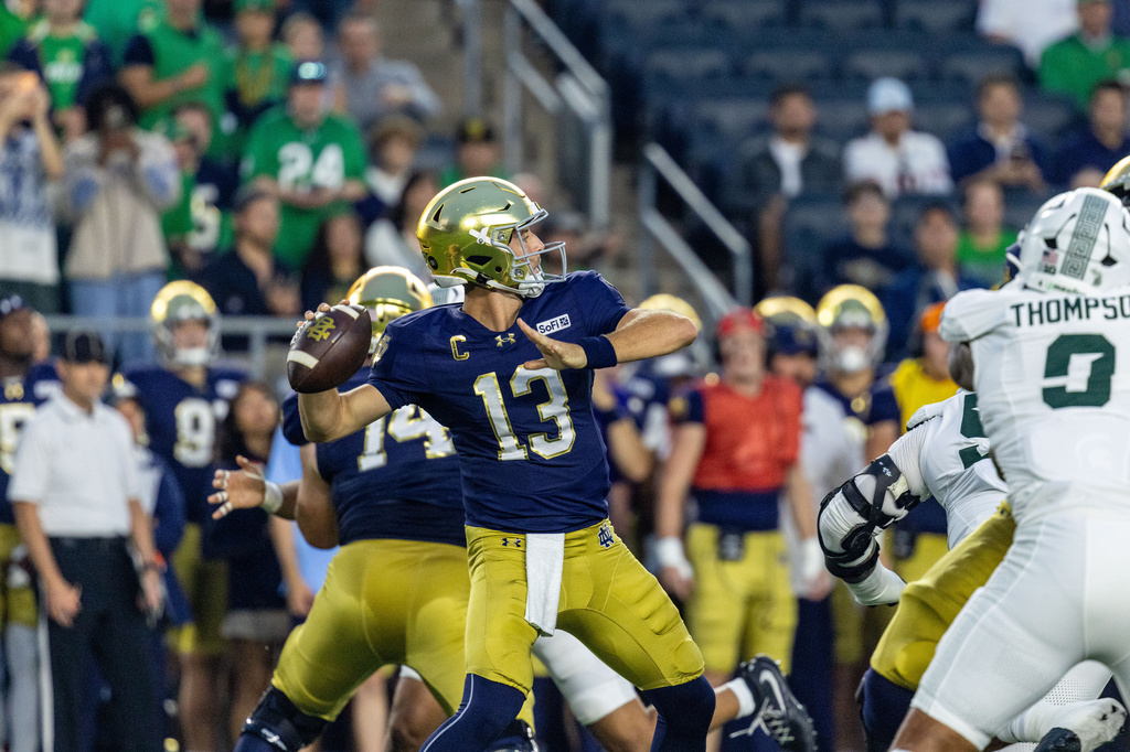 Notre Dame quarterback CJ Carr (13) throws a 61 yard completion to wide receiver Micah Gilbert (14) during the first half of a college football game against Michigan State, Saturday, Sept. 19, 2026, in South Bend, Ind. (AP Photo/Paul Barnick)