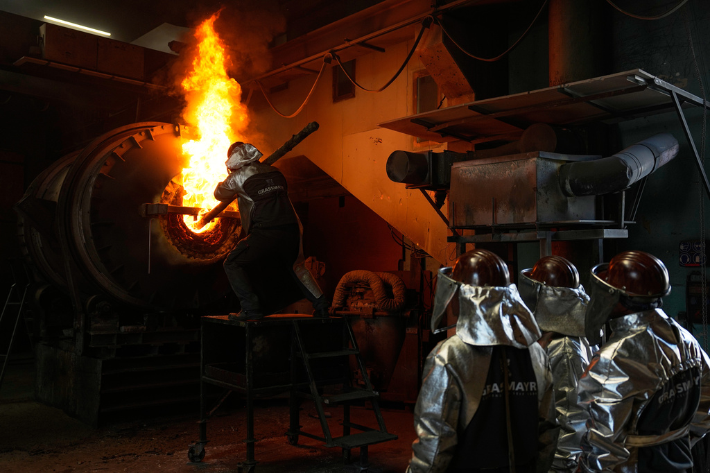 Employees use a melting furnace at the 400-year-old family-owned bell foundry Grassmayr in Innsbruck, Austria, Friday, July 17, 2026. (AP Photo/Matthias Schrader)