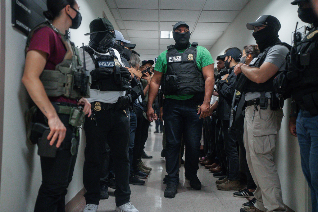 FILE - Masked federal agents wait outside an immigration courtroom, July 8, 2025, in New York. (AP Photo/Olga Fedorova, File)