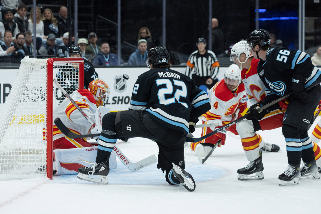 Calgary Flames goaltender Devin Cooley (1) watches the puck fly against Utah Mammoth center Jack McBain (22) during the second half of an NHL hockey game Wednesday, Oct. 15, 2025, in Salt Lake City. (AP Photo/Melissa Majchrzak)
