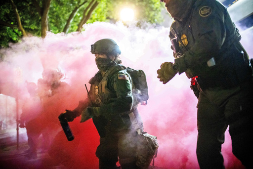 Police and federal officers throw gas canisters to disperse protesters near a U.S. Immigration and Customs Enforcement facility in Portland, Ore. on Sunday, Oct. 5, 2025. (AP Photo/Ethan Swope) Police and federal officers throw gas canisters to disperse protesters near a U.S. Immigration and Customs Enforcement facility in Portland, Ore. on Sunday, Oct. 5, 2025. (AP Photo/Ethan Swope)