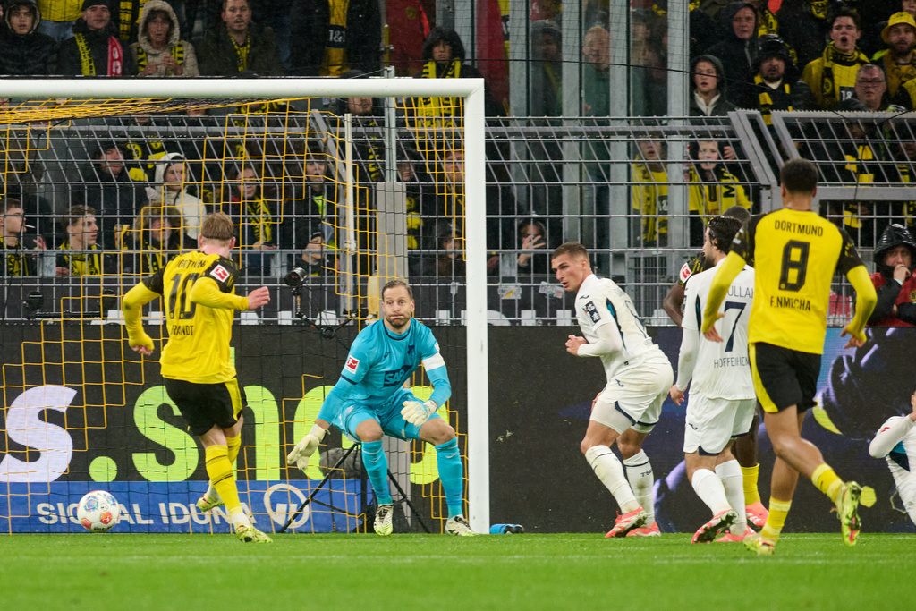 Borussia's Julian Brandt, left, scores the opening goal during Germany Bundesliga soccer match between Borussia Dortmund and TSG 1899 Hoffenheim, in Dortmund, Germany, Sunday, Dec. 7, 2025. (Bernd Thissen/dpa via AP)