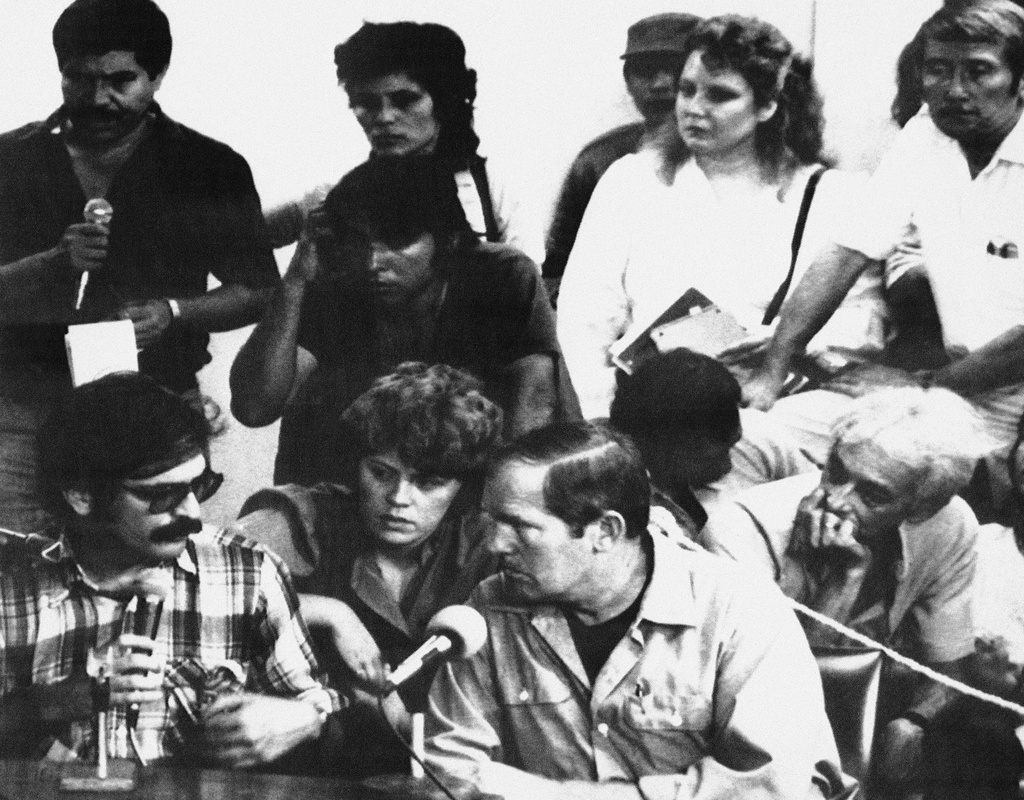FILE - Eugene Hasenfus (bottom, center) listens as Jose Peres translates the tribunal proceedings from Spanish into English in Managua, Friday, Oct. 31, 1986. (AP Photo/Orozco, File)