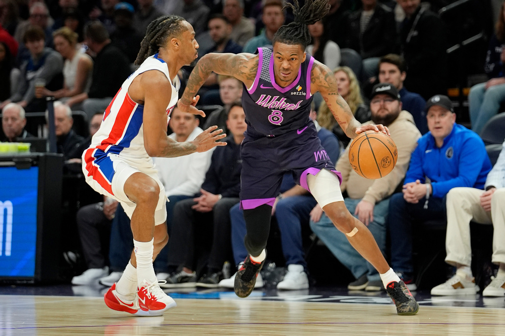 Minnesota Timberwolves guard Bones Hyland (8) works around Detroit Pistons guard Daniss Jenkins, left, in the first quarter of an NBA basketball game Saturday, March 28, 2026, in Minneapolis. (AP Photo/Bruce Kluckhohn)