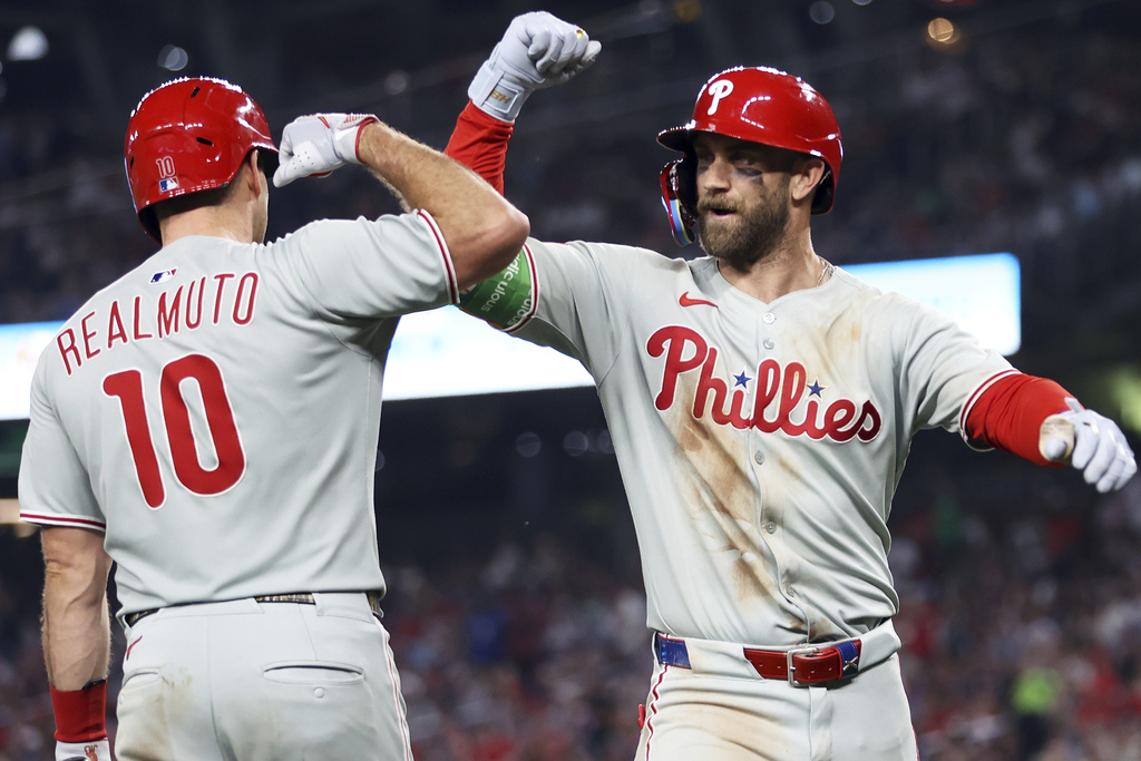 Philadelphia Phillies' Bryce Harper celebrates with Philadelphia Phillies' J.T. Realmuto after hitting a home run during the seventh inning of a baseball game against the Washington Nationals, Friday, Aug. 15, 2025, in Washington. (AP Photo/Daniel Kucin Jr.)