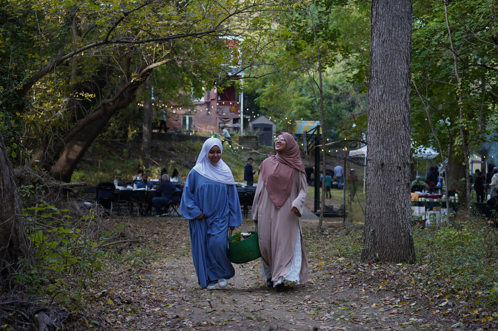 Collins Avenue area neighbors leave the Baltimore Gift Economy's third annual "Finding Home" gathering with potted vegetables, Sunday, Oct. 19, 2025, in Baltimore. (AP Photo/Jessie Wardarski)