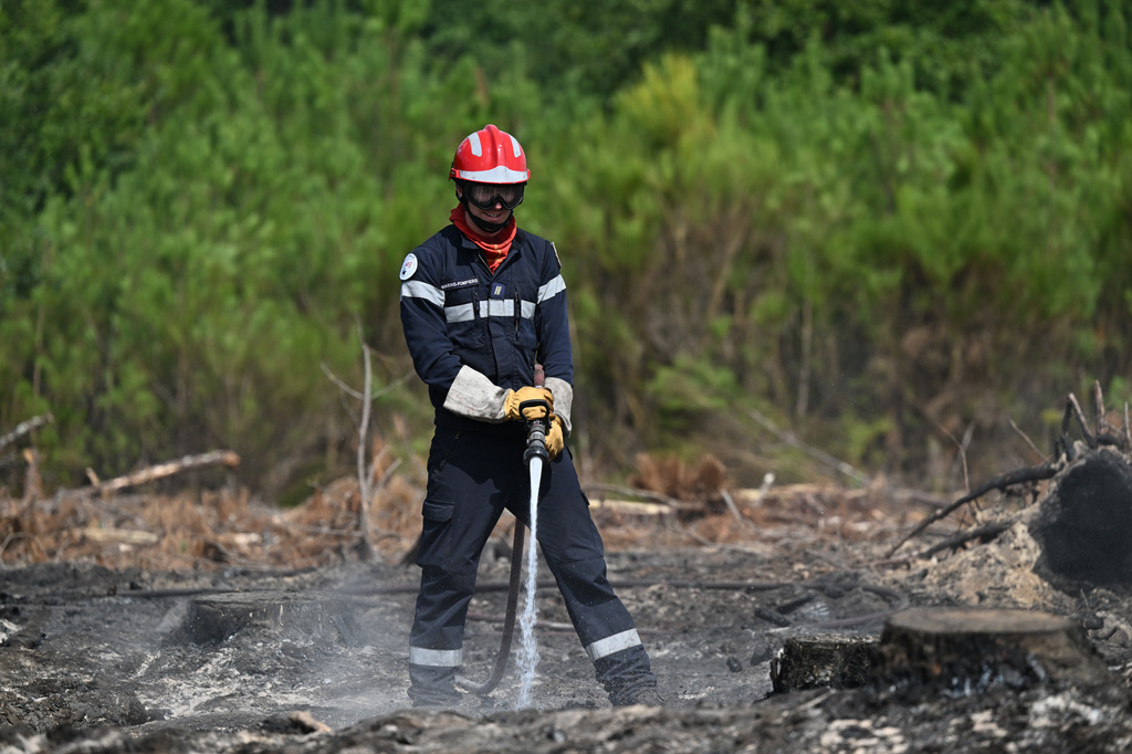 A firefighter works to extinguished fires near Lege-Cap-Ferret, southwestern France, Friday, July 31, 2026. (AP Photo/Emma Da Silva)