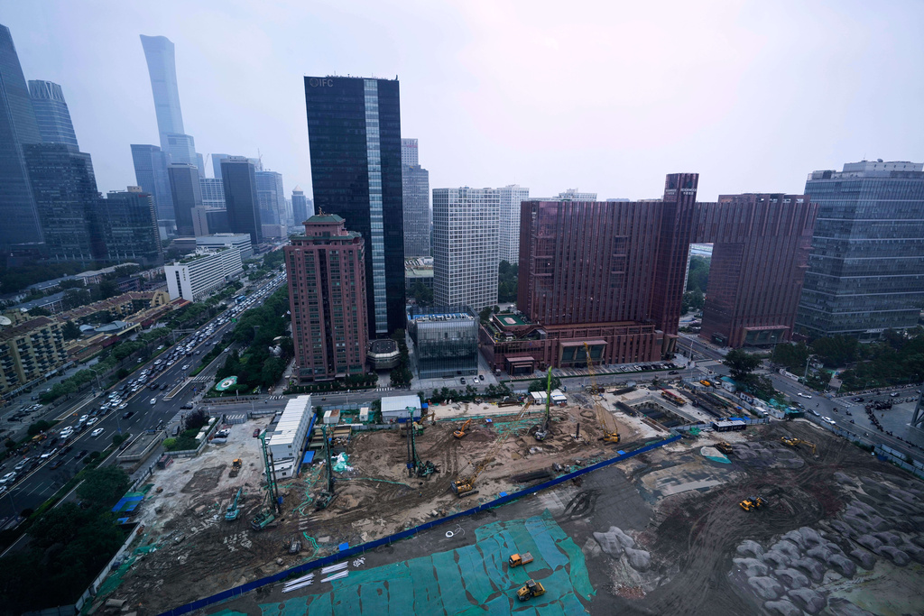 Earth movers transport soil at a construction site in Beijing, China, Friday, July 11, 2025. (AP Photo/Mahesh Kumar A.)