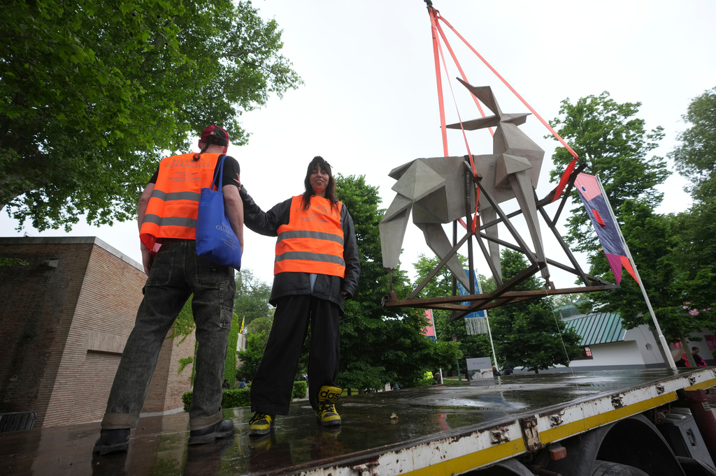 Ukrainian artist Zhanna Kadyrova poses flanked by Ukrainian artist Nikita Kravtsov next to her installation 'The Origami Deer', at the Venice 2026 Biennale Art, Italy, Tuesday, May 5, 2026. (AP Photo/Luca Bruno)