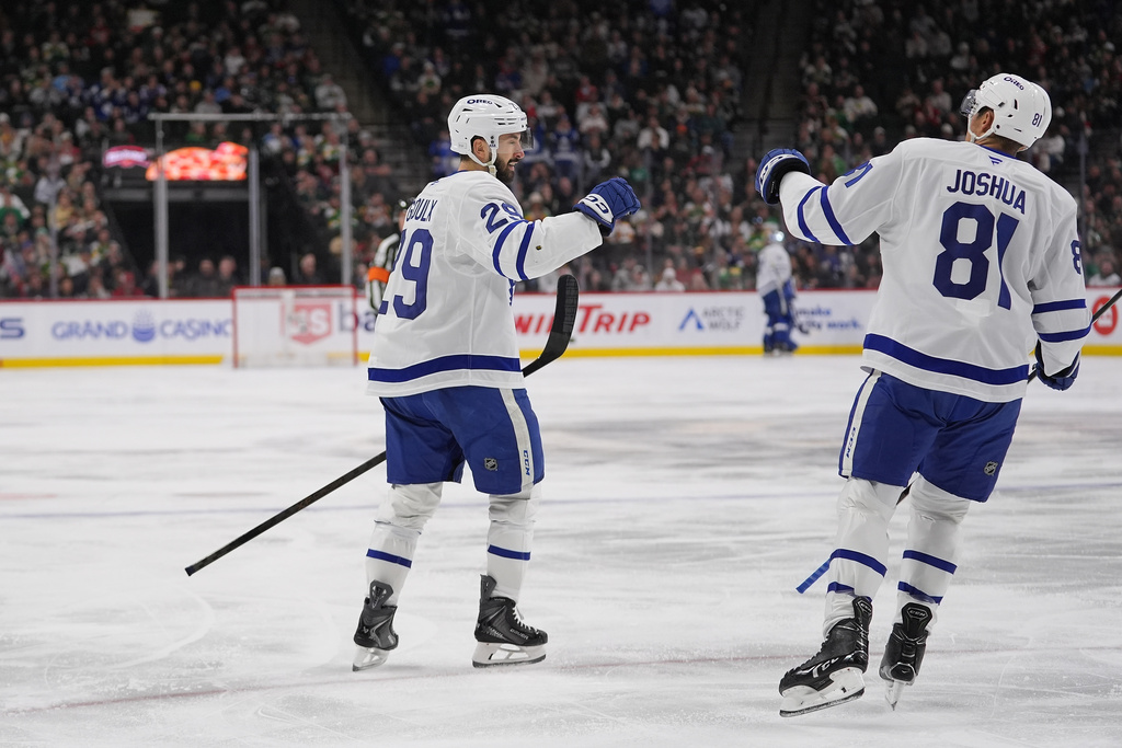 Toronto Maple Leafs center Benoit-Olivier Groulx, left, celebrates with center Daokta Joshua (81) after scoring a goal during the second period of an NHL hockey game against the Minnesota Wild, Sunday, March 15, 2026, in St. Paul, Minn. (AP Photo/Abbie Parr)