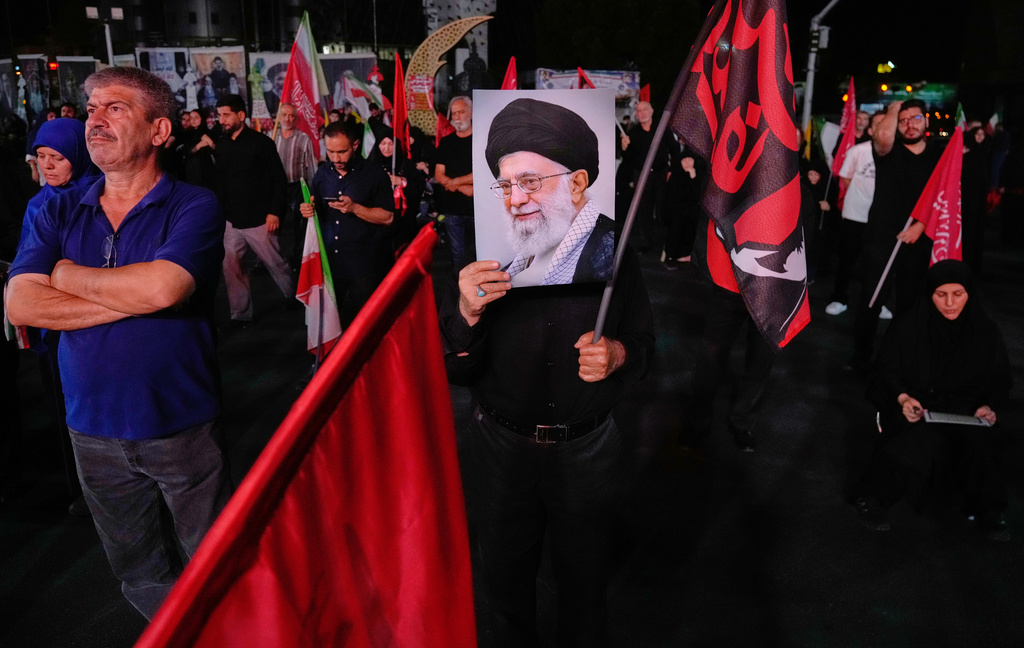 A man holds a poster of the late Iranian Supreme Leader Ayatollah Ali Khamenei in a gathering commemorating him at a square in Tehran, Saturday, July 11, 2026. (AP Photo/Vahid Salemi)