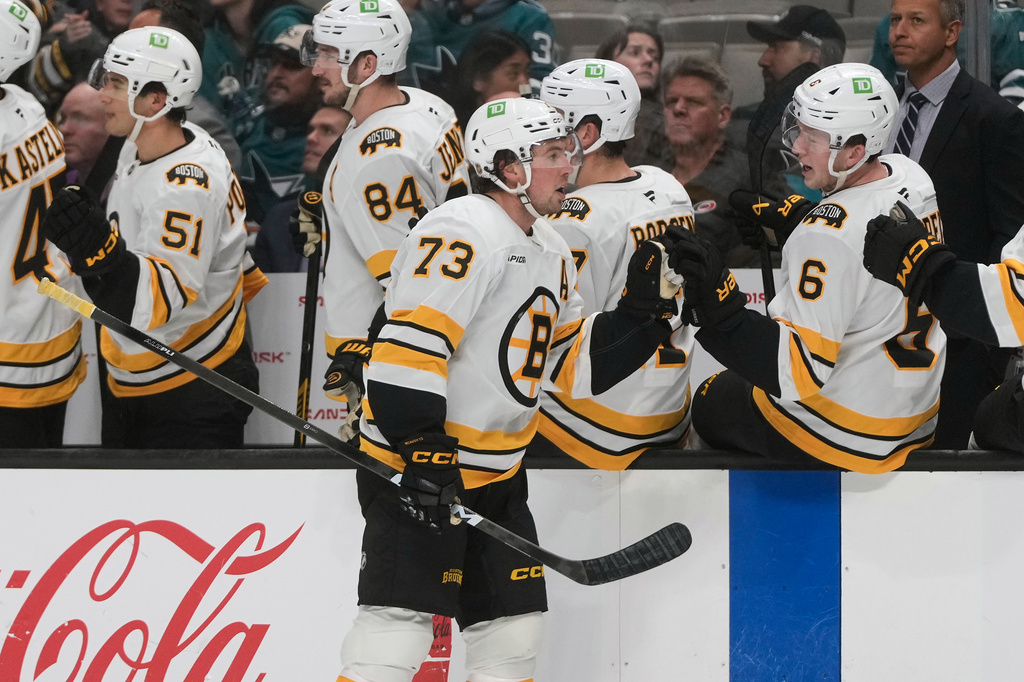 Boston Bruins defenseman Charlie McAvoy (73) is congratulated by teammates after scoring during the first period of an NHL hockey game, Tuesday, Oct. 13, 2026, San Jose, Calif. (AP Photo/Jeff Chiu)