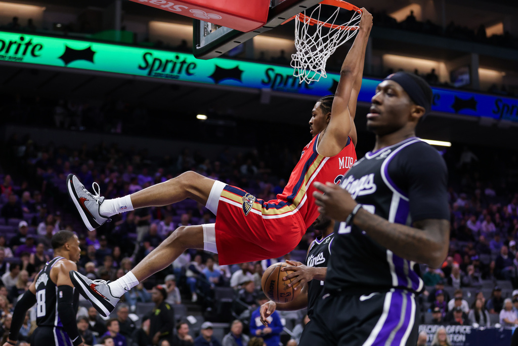 New Orleans Pelicans forward Trey Murphy III (25) hangs on the rim after dunking the ball against the Sacramento Kings during the first half of an NBA basketball game Thursday, March 5, 2026, in Sacramento, Calif. (AP Photo/Scott Marshall)