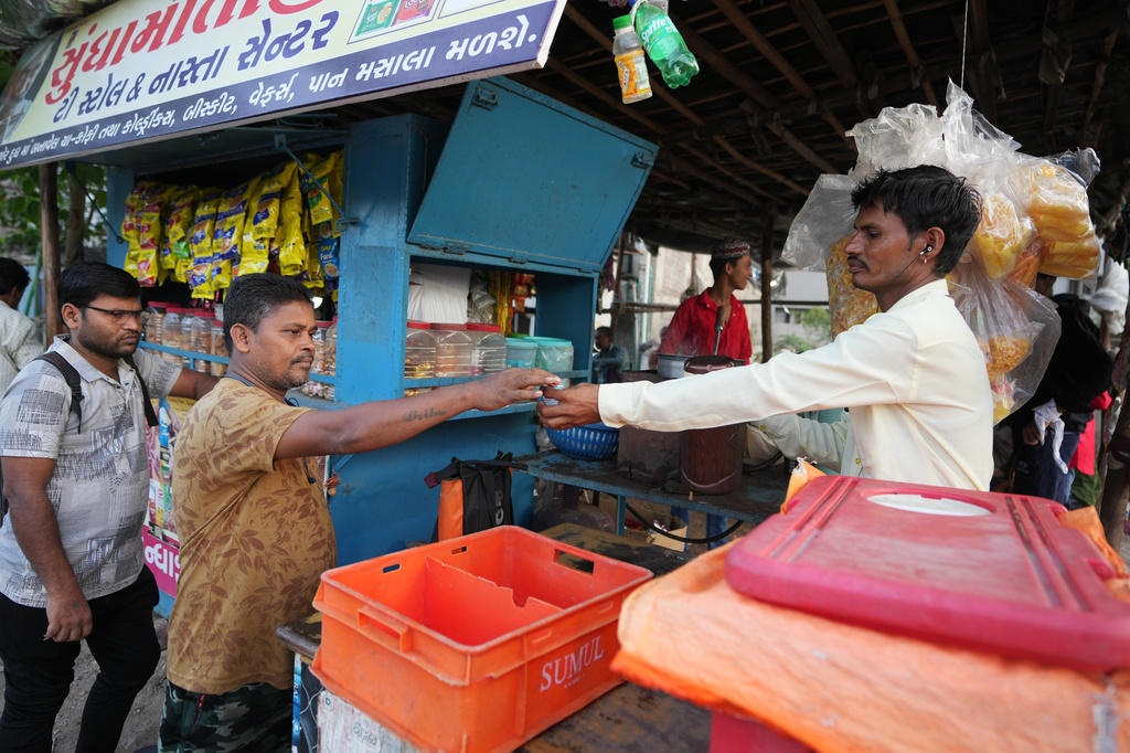 Power loom factory worker Sibaram Pradhan takes a tea from a stall near the factory where he works in Surat, India, Thursday, May 28, 2026. (AP Photo/Ajit Solanki)