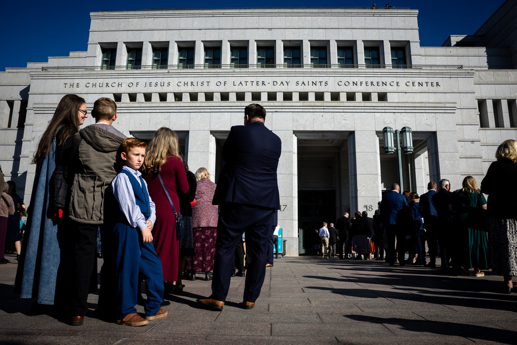 Walton Kelley, 8, from Murray, left, and others wait in line to enter The Church of Jesus Christ of Latter-day Saints' Conference Center for President Russell M. Nelson's funeral in Salt Lake City on Oct. 7, 2025. (Tess Crowley/The Deseret News via AP)