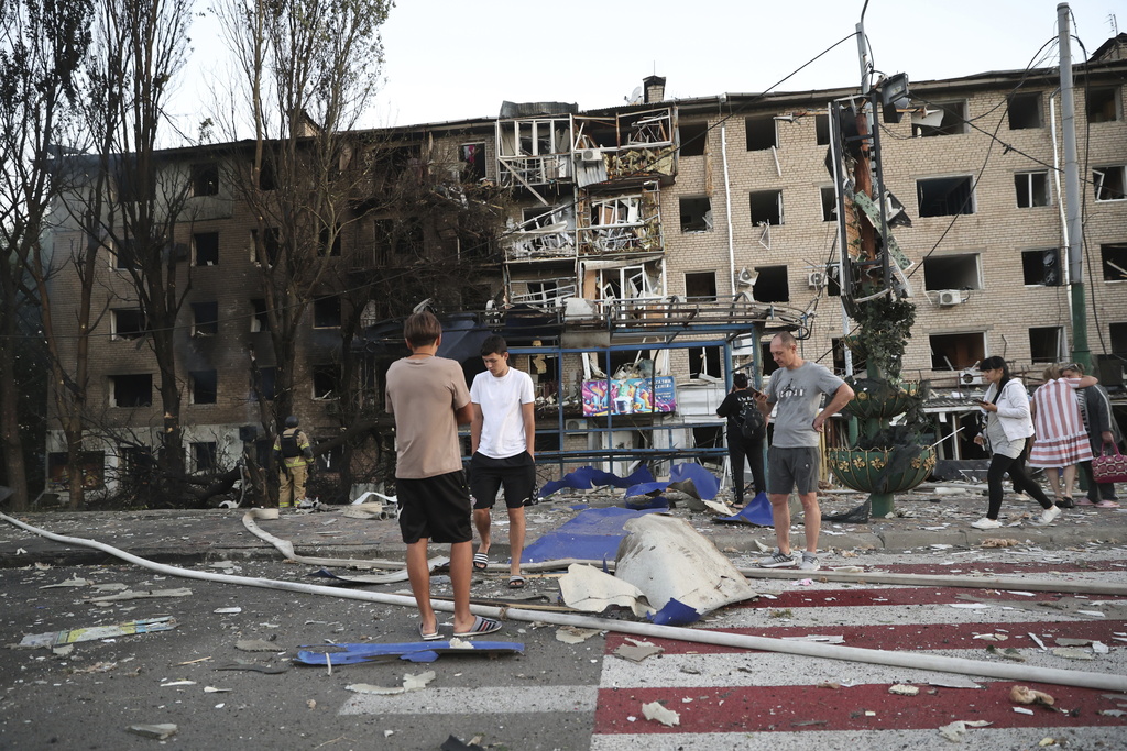 Local residents stand near their destroyed home following Russian air strike in Zaporizhzhia, Ukraine, Saturday, Aug. 30, 2025. (AP Photo/Kateryna Klochko)