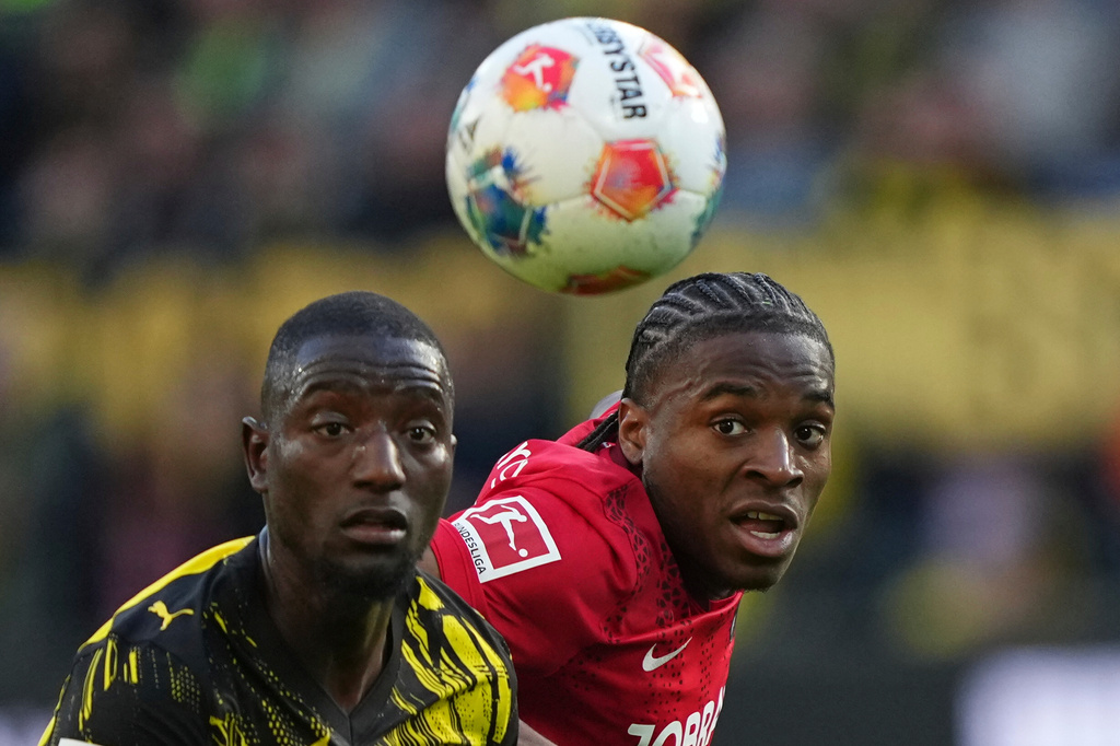 Dortmund's Serhou Guirassy, left, and Freiburg's Bruno Ogbus challenge for the ball during the German Bundesliga soccer match between Borussia Dortmund and SC Freiburg in Dortmund, Germany, Sunday, April 26, 2026. (AP Photo/Martin Meissner)