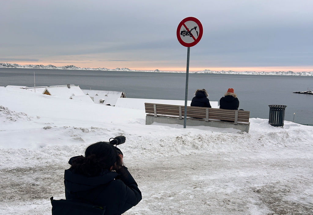 An AP journalist films people sitting by the sea in Nuuk, Greenland, Thursday, Jan. 15, 2026. (AP Photo/Emma Burrows)