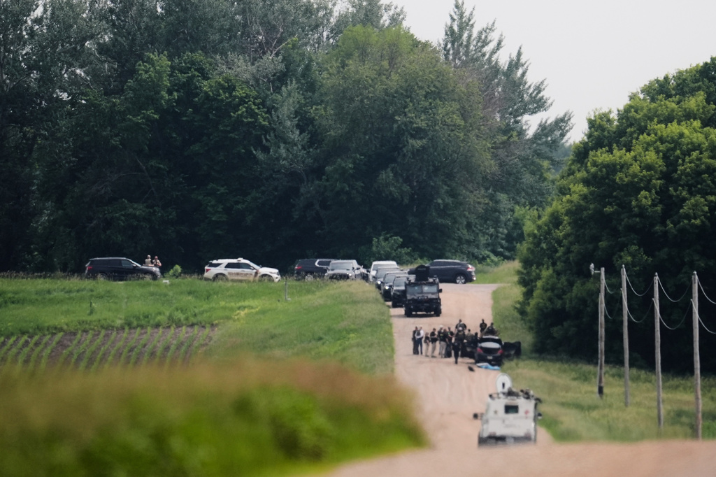 FILE - Members of law enforcement agencies investigate near a vehicle suspected to belong to shooting suspect, Vance Boelter, June 15, 2025, in Belle Plaine, Minn. (AP Photo/George Walker IV, File)