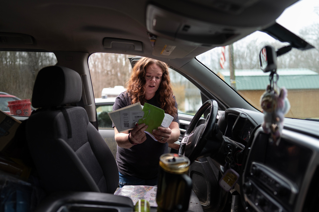 Ashley Nicole Dixon looks through her truck for electric bills outside one of her homes in Danese, W.Va., Saturday, March 21, 2026. (AP Photo/Carolyn Kaster)