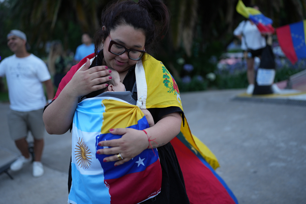 Ariana Hernandez and embraces her son Emmanuel during a demonstrate ahead of the Nobel Peace Prize ceremony where Venezuelan Maria Corina Machado is among this year's laureates, in Buenos Aires, Argentina, Saturday, Dec. 6, 2025. (AP Photo/Rodrigo Abd)
