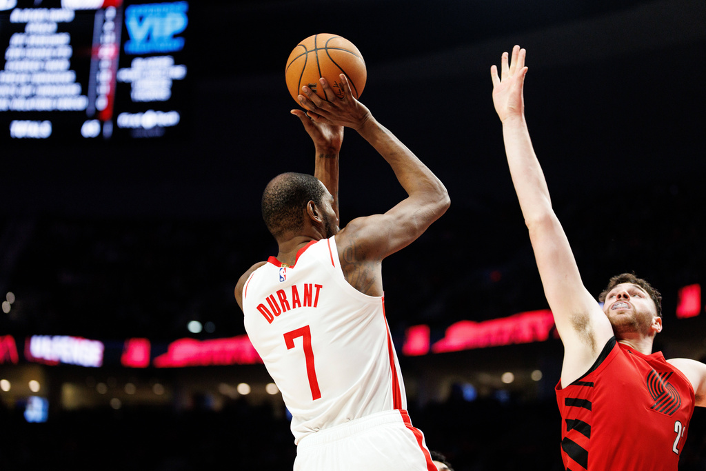 Houston Rockets forward Kevin Durant, left, shoots over Portland Trail Blazers center Donovan Clingan, right, during the second half of an NBA basketball game Friday, Jan. 9, 2026, in Portland, Ore. (AP Photo/Howard Lao)