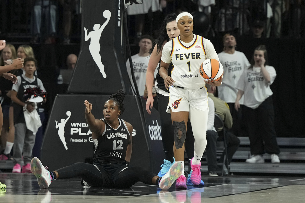 Las Vegas Aces guard Chelsea Gray (12) reacts after a foul by the Indiana Fever in the first half of Game 1 of a WNBA basketball playoff semifinals series Sunday, Sept. 21, 2025, in Las Vegas. (AP Photo/Candice Ward)