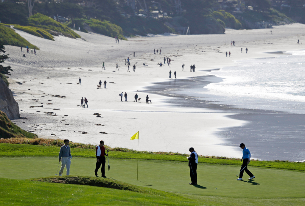 FILE - In this Feb. 6, 2013, file photo, Roberto Castro, right, walks to his ball on the tenth green of the Pebble Beach Golf Links during a practice round of the AT&T Pebble Beach Pro-Am golf tournament in Pebble Beach, Calif. It's played on one of the world's most picturesque courses on the first weekend after the Super Bowl, offering magnificent views of the Monterey Peninsula to golf fans still digging out from the snow. (AP Photo/Eric Risberg, File)