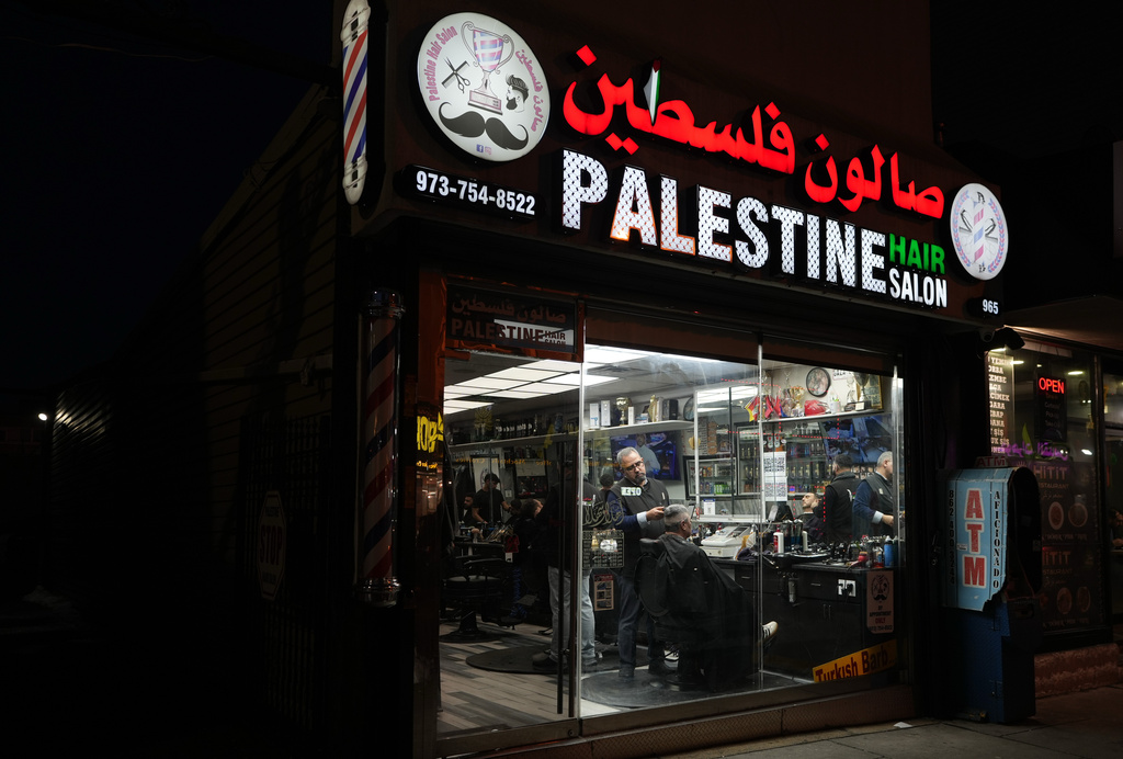 Raed Odeh, the owner and top barber of the Palestine Hair Salon trims the hair of a man in Paterson, N.J., during Ramadan on Friday, Feb. 27, 2026. (AP Photo/Luis Andres Henao)