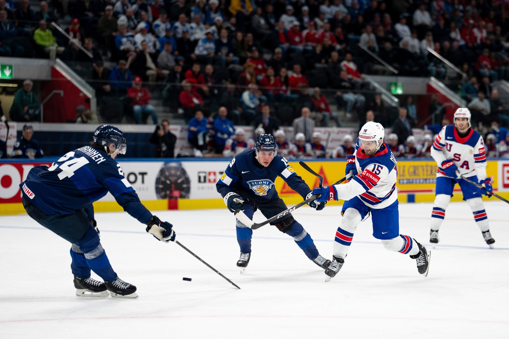 USA's Tommy Novak, right, shoots the puck past Finland's Hannes Bjorninen, left, and Waltteri Merela during the Men's Ice Hockey World Championship preliminary round game between Finland and the USA in Zurich, Switzerland, Monday, May 18, 2026. (Claudio Thoma/Keystone via AP)