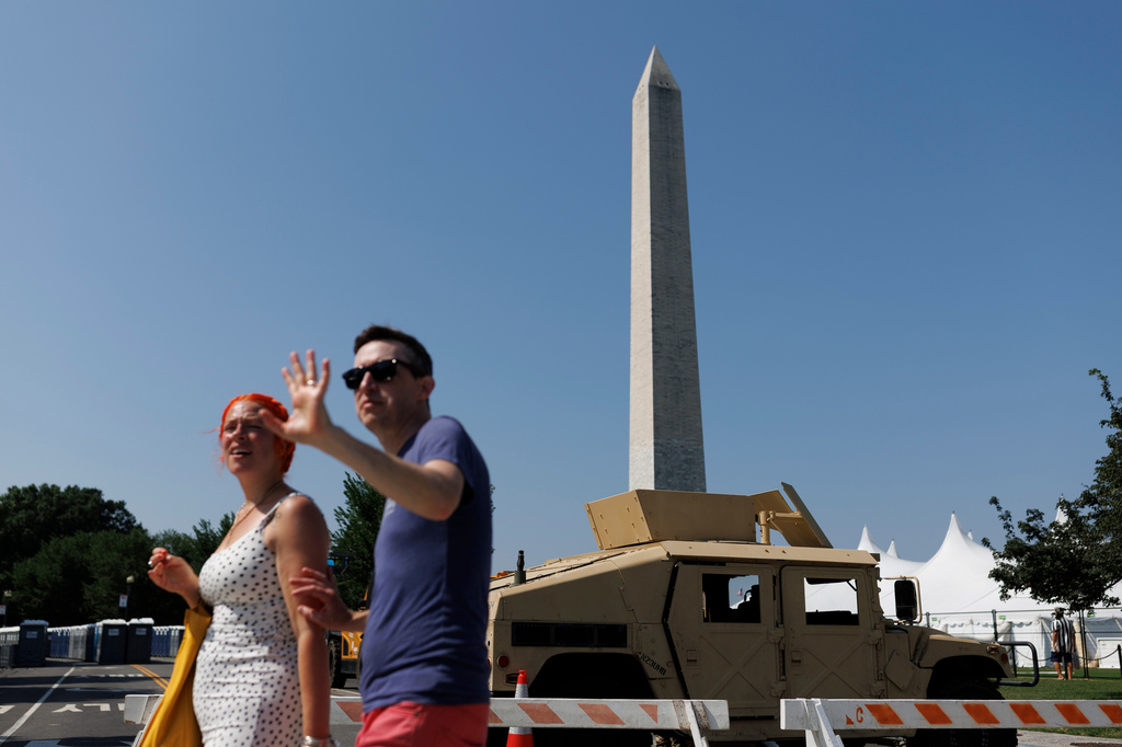 People cross 15th Street Northwest as a National Guard Humvee blocks the roadway, Wednesday, July 1, 2026, in Washington. (AP Photo/Tom Brenner)