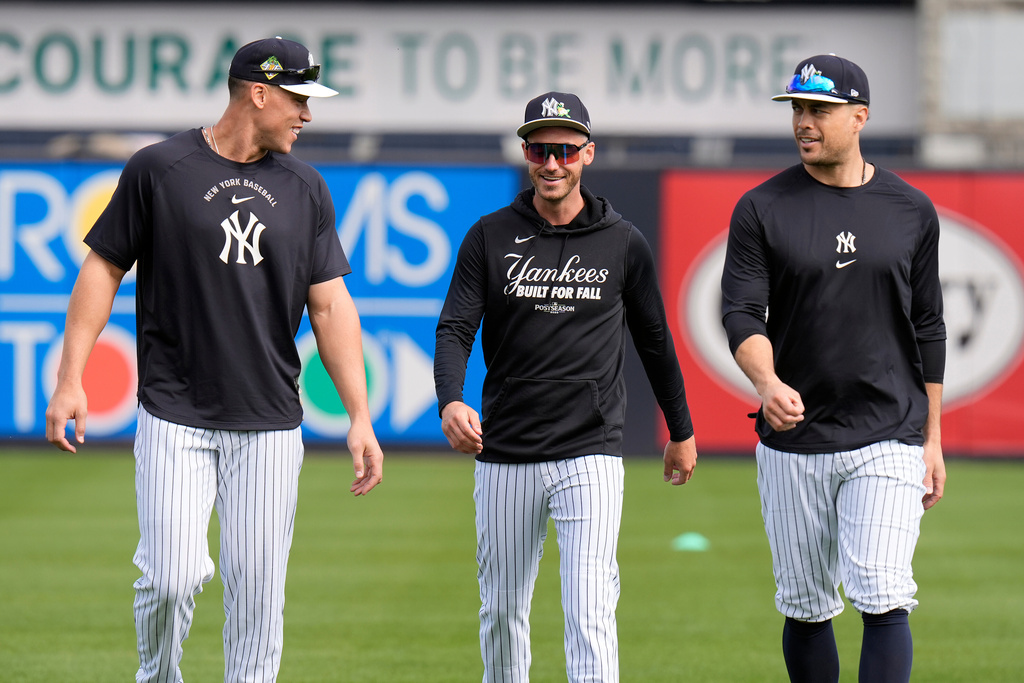 New York Yankees, from left, right fielder Aaron Judge, left fielder Cody Bellinger, and designated hitter Giancarlo Stanton chat after running during a spring training baseball workout Monday, Feb. 16, 2026, in Tampa, Fla. (AP Photo/Chris O'Meara)