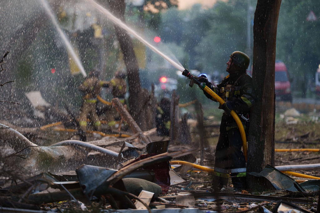 Rescue workers try to put out a fire at a residential building after a Russian strike on Kyiv, Ukraine, on Sunday, May 24, 2026. (AP Photo/Evgeniy Maloletka)