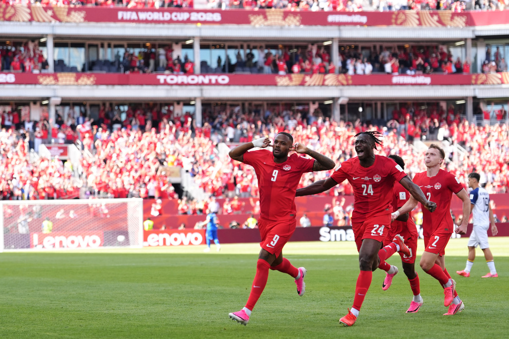 Canada's Cyle Larin (9) celebrates after scoring his sides first goal of the game with Promise David (24) during the second half of the World Cup Group B soccer match between Canada and Bosnia, Friday, June 12, 2026, in Toronto. ( (AP Photo/Sam Balkansky)