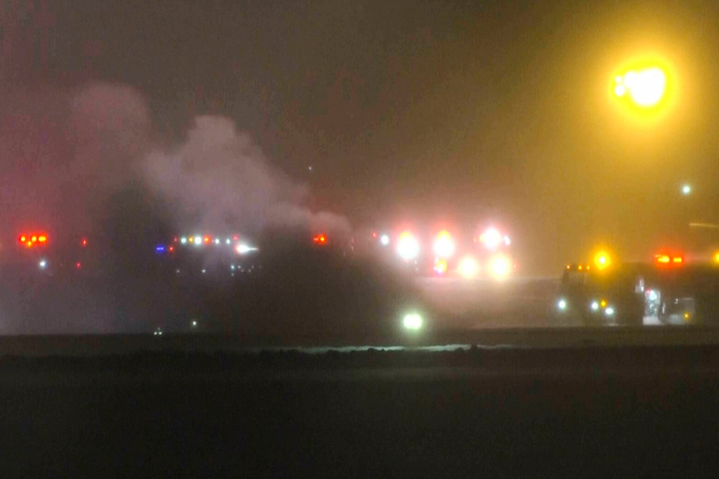 This image taken from video provided by WABI television, emergency cervices work on a scene of the Bombardier Challenger 600 crash at the Bangor Airport in Maine, late Sunday, Jan. 25, 2026. (WABI via AP)