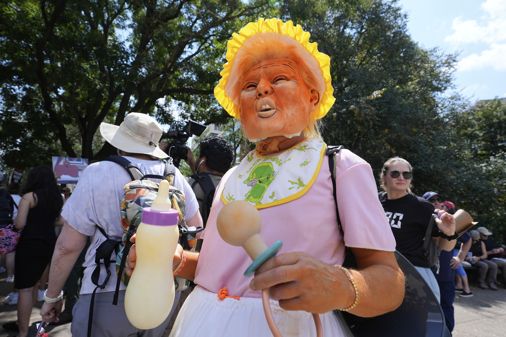 Bob Sledzaus, of Reston, Va., wears a President Donald Trump mask and costume during a protest of Trump's federal takeover of policing of the District of Columbia, Saturday, Aug. 16, 2025, in Washington. (AP Photo/Alex Brandon)