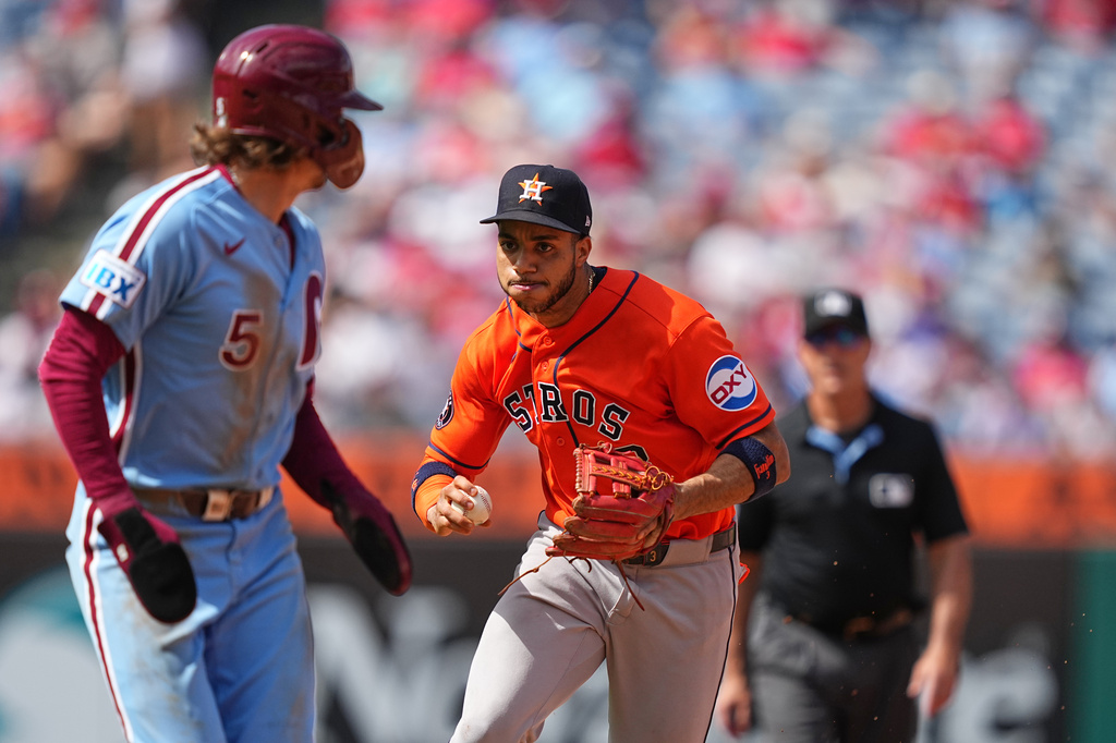 Houston Astros shortstop Jeremy Peña, center, runs down Philadelphia Phillies' Bryson Stott during the fifth inning of a baseball game, Thursday, Sept. 10, 2026, in Philadelphia. (AP Photo/Matt Rourke)