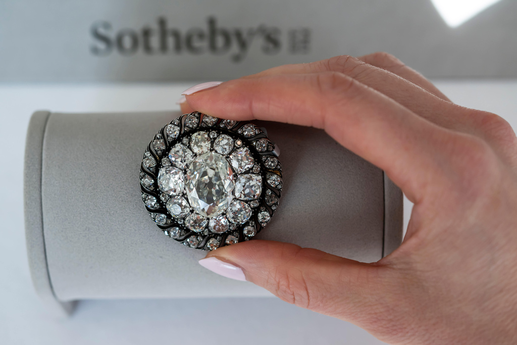 A Sotheby's employee displays an old mine-cut diamond brooch or pendant owned by Emperor Napoleon I, circa 1810, during a preview at Sotheby's in Geneva, Switzerland, Thursday, Nov. 6, 2025. (Martial Trezzini/Keystone via AP)