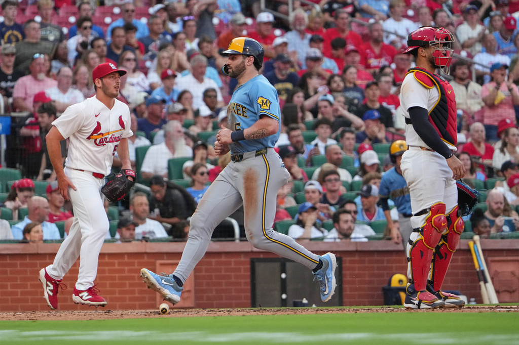 Milwaukee Brewers' Garrett Mitchell, center, scores between St. Louis Cardinals starting pitcher Andre Pallante, left, and catcher Iván Herrera during the third inning of a baseball game Thursday, July 9, 2026, in St. Louis. (AP Photo/Jeff Roberson)