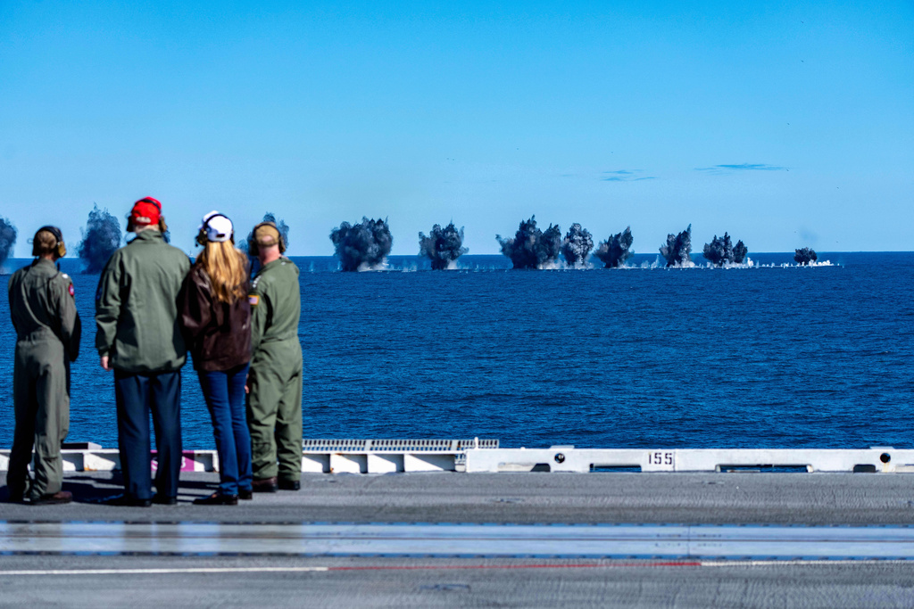 President Donald Trump and first lady Melania Trump watch bombs explode during a naval sea power demonstration aboard the USS George H.W. Bush aircraft carrier in the Atlantic Ocean off the coast of Norfolk, Va., Oct. 5, 2025. (AP Photo/Alex Brandon)