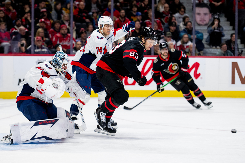 Ottawa Senators' Stephen Halliday (83) screens Washington Capitals goalie Logan Thompson (48) as a shot from the point makes it way towards the net during second period NHL hockey action on New Year's Day in Ottawa, on Thursday, Jan. 1, 2026. (Spencer Colby/The Canadian Press via AP)