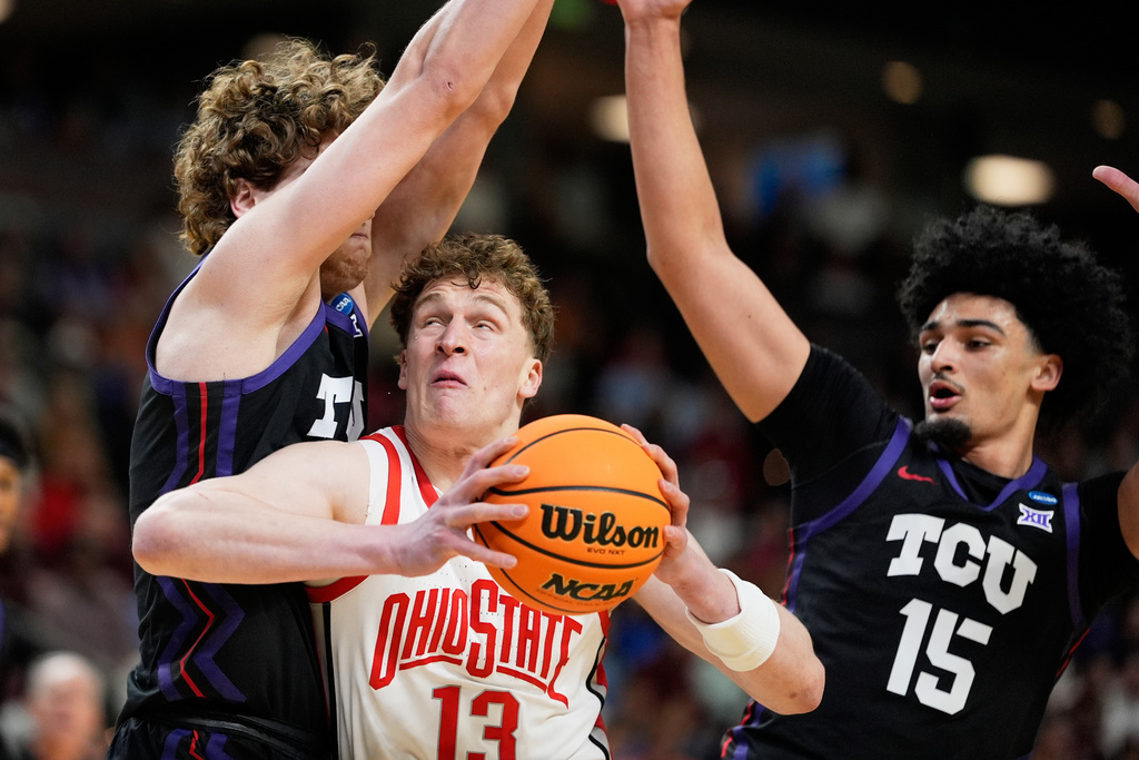 Ohio State center Christoph Tilly drives to the basket between TCU guard Liutauras Lelevicius and forward David Punch during the first half in the first round of the NCAA college basketball tournament, Thursday, March 19, 2026, in Greenville, S.C. (AP Photo/Chris Carlson)