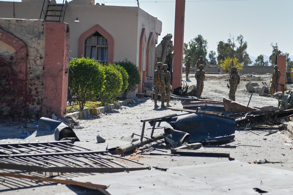 Army soldiers stand guard next to a damaged area at the main gate of an army-run cadet college that was assaulted by militants on Monday, in Wana, a city in the northwestern Pakistani district South Waziristan bordering with Afghanistan, Thursday, Nov. 13, 2025. (AP Photo/Ahsan Shahzad)