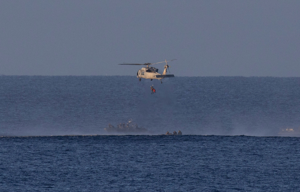 In this photo provided by NASA, a helicopter lifts up one of the astronauts from Artemis II after splashdown in the Pacific Ocean off the coast of California, Friday, April 10, 2026. (Joel Kowsky/NASA via AP)