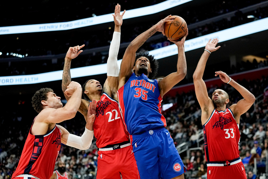 Detroit Pistons forward Tolu Smith, third from left, shoots against Los Angeles Clippers center Brook Lopez, guard Jordan Miller, and forward Nic Batum, from left, during the first half of an NBA basketball game Saturday, Jan. 10, 2026, in Detroit. (AP Photo/Ryan Sun)