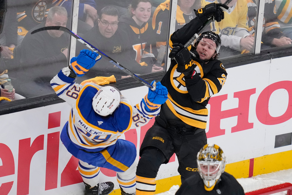 Boston Bruins defenseman Andrew Peeke, right, knocks Buffalo Sabres left wing Beck Malenstyn (29) to the ice during the first period in Game 3 of a first-round NHL hockey Stanley Cup playoff series, Thursday, April 23, 2026, in Boston. (AP Photo/Charles Krupa)