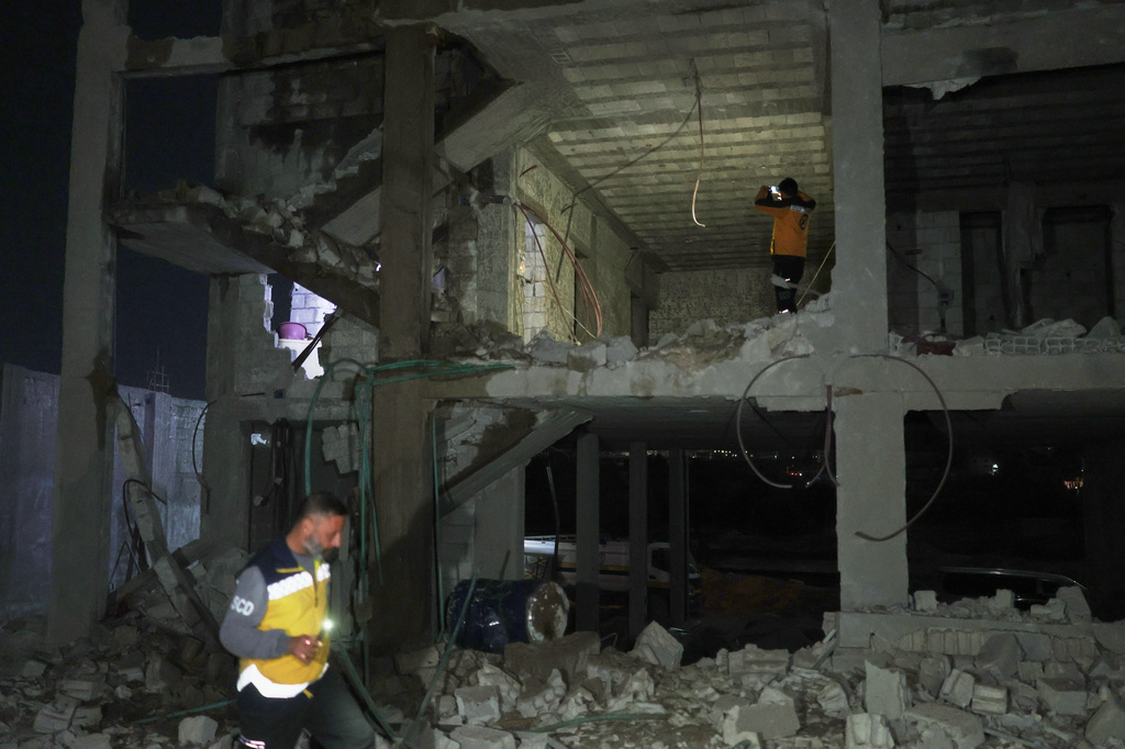 FILE — Members of the Syrian Civil Defense inspect a building after debris from an Iranian missile fell, injuring at least four people, including three children, according to Syria's state news agency SANA, in the town of Ain Terma, near Damascus, Syria, March 1, 2026. (AP Photo/Ghaith Alsayed, File)