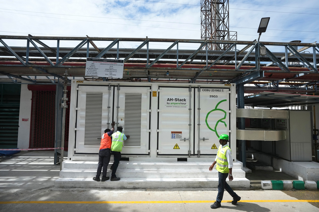 FILE - Team leader K. Sridhar, center, closes the doors after a routine check of lithium-ion batteries of 500-kilowatt battery energy storage system in Thiruvallur District, on the outskirts of Chennai, India, July16, 2024. (AP Photo/Mahesh Kumar A., File)