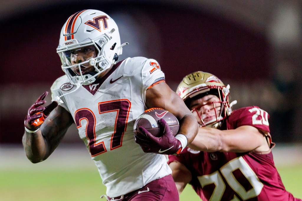 FILE - Virginia Tech running back Marcellous Hawkins (27) is tackled by Florida State linebacker Blake Nichelson (20) during the first half of an NCAA college football game, Nov. 15, 2025, in Tallahassee, Fla. (AP Photo/Colin Hackley, File)